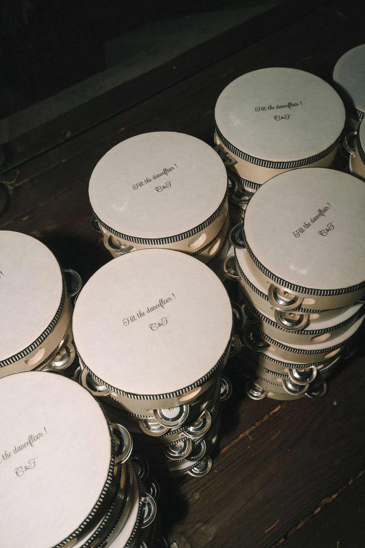 Several round pale metal tins with printed lids are stacked in groups on a dark wooden surface.