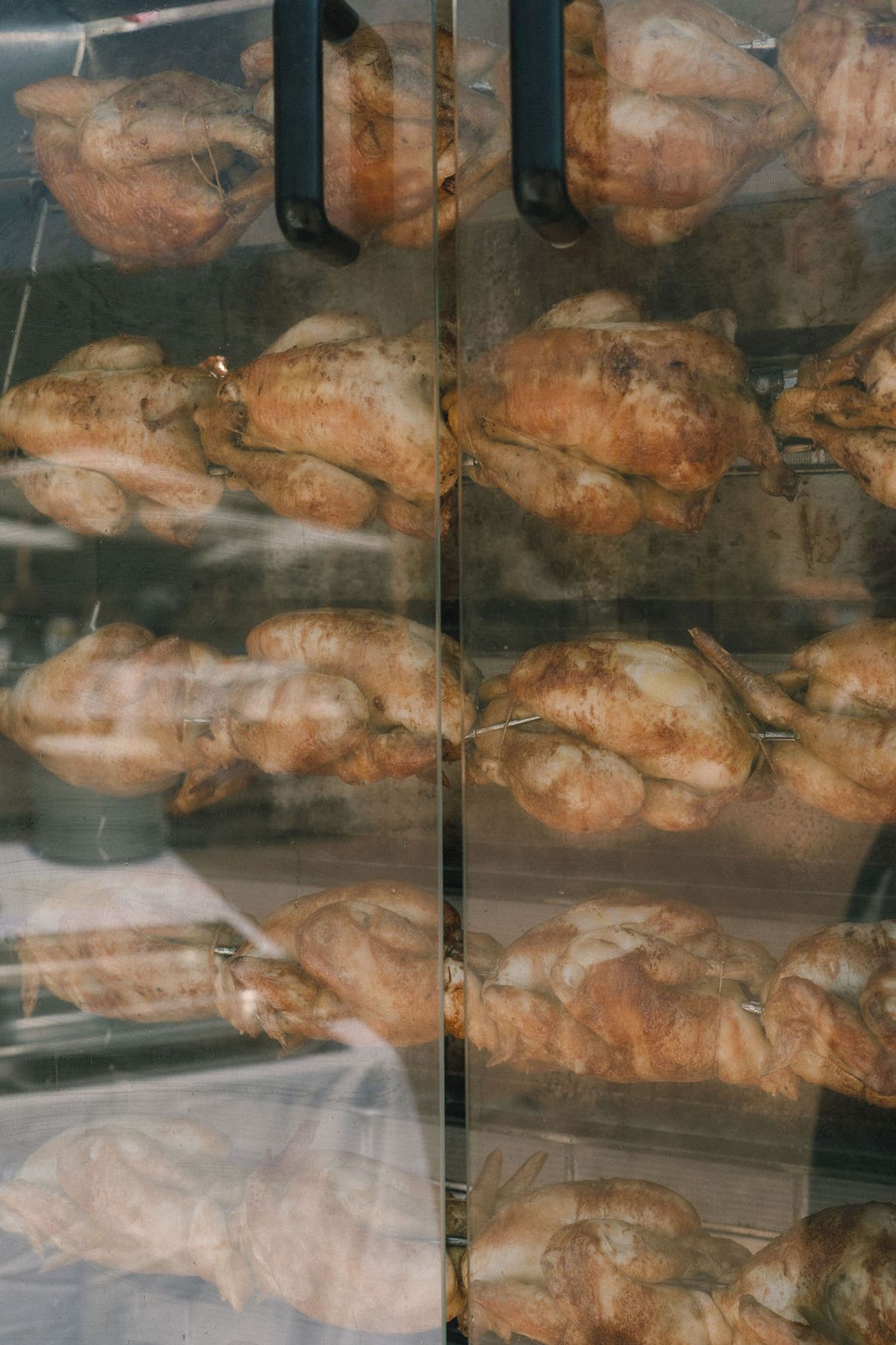 Rows of golden croissants and pastries arranged on shelves behind glass doors.