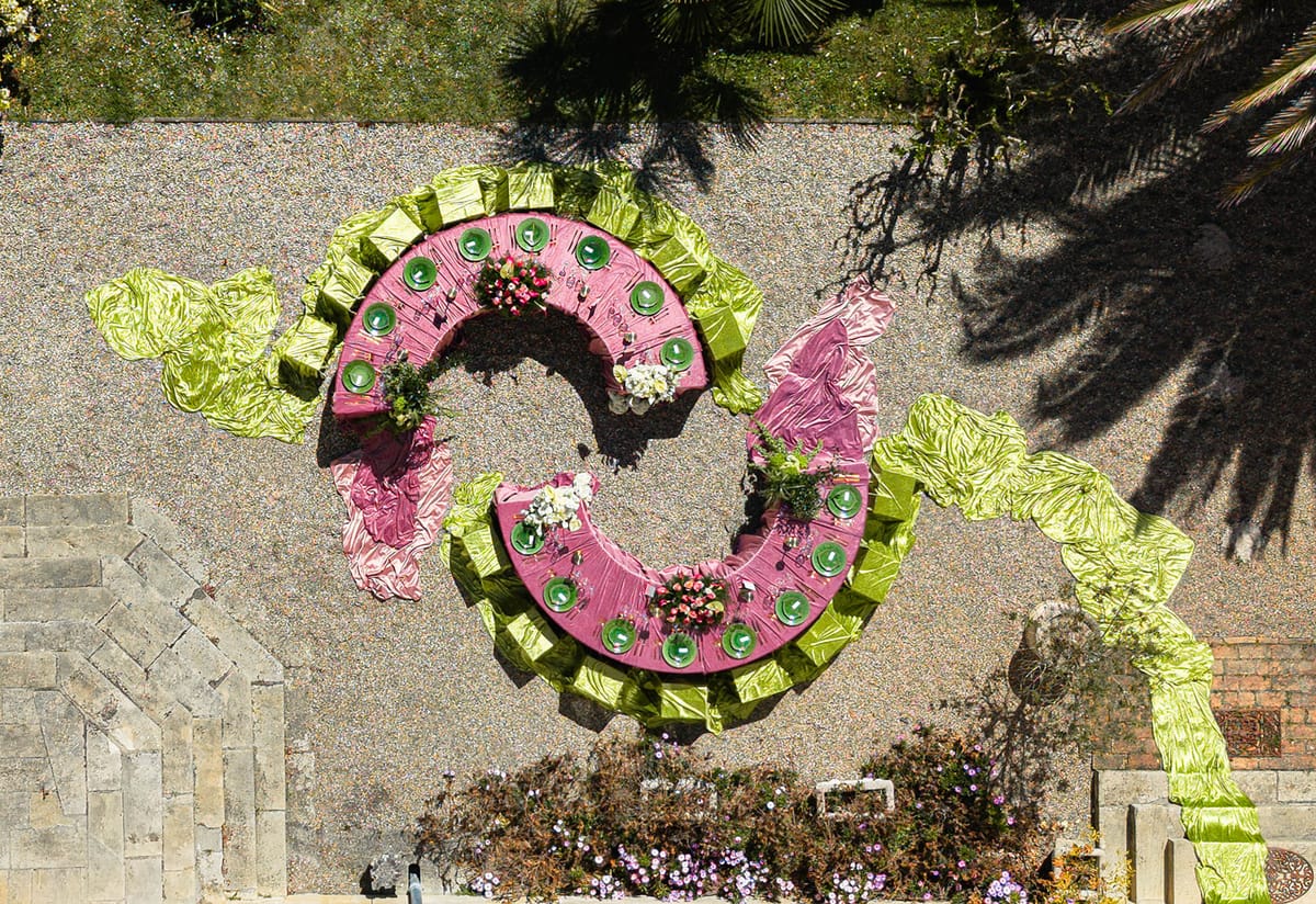 Aerial view of the crescent tables and draped velvet beside the chateau's stone terrace