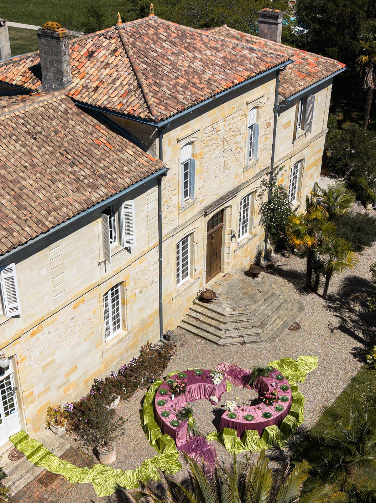 Aerial view of the chateau rooftop with the dressed reception tables in the courtyard below