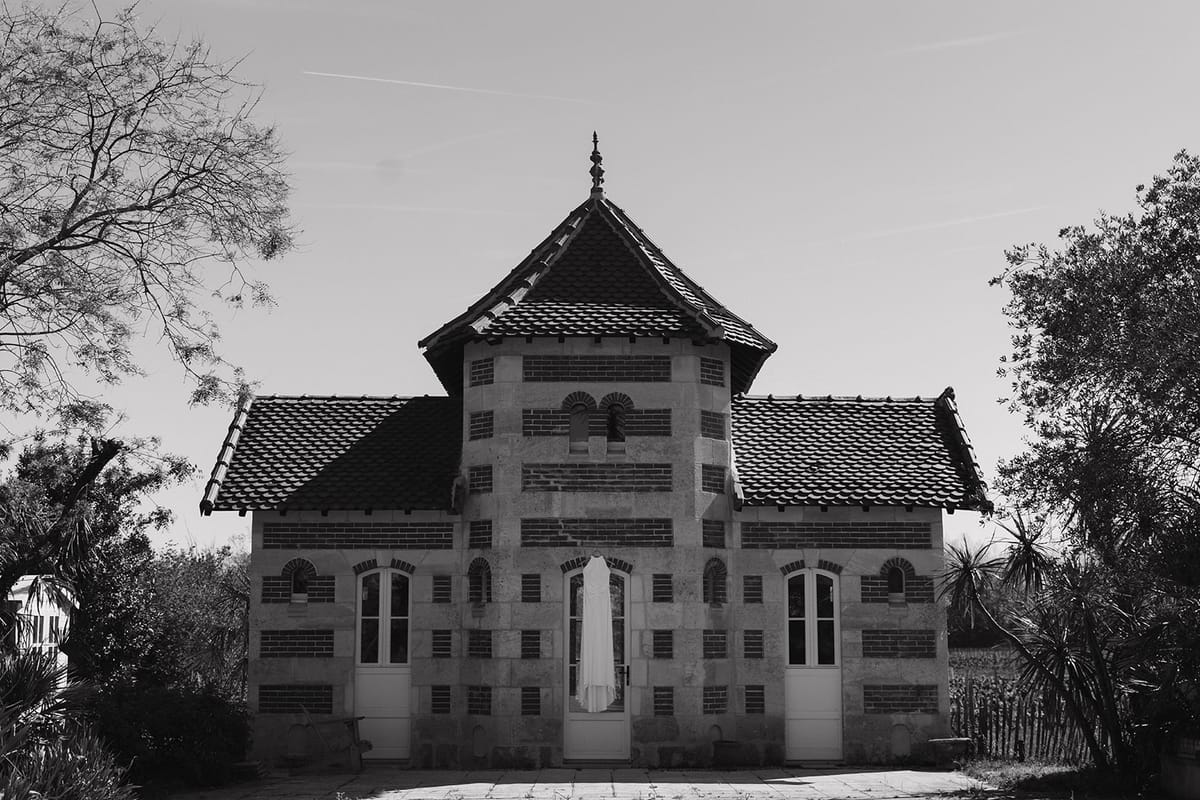 Black and white view of a brick and stone pavilion among trees