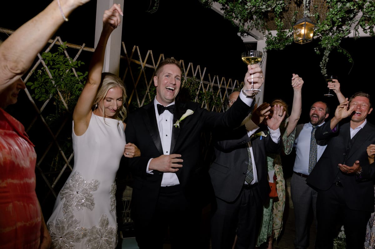 Couple cheering with guests at the evening party