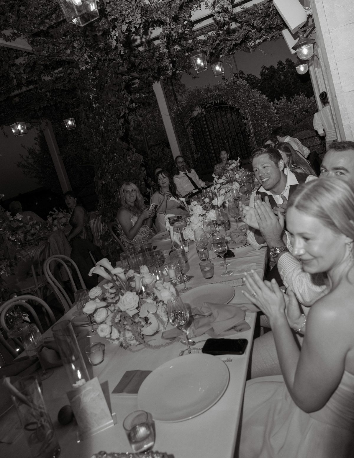 Black and white photo of guests applauding at the dinner table