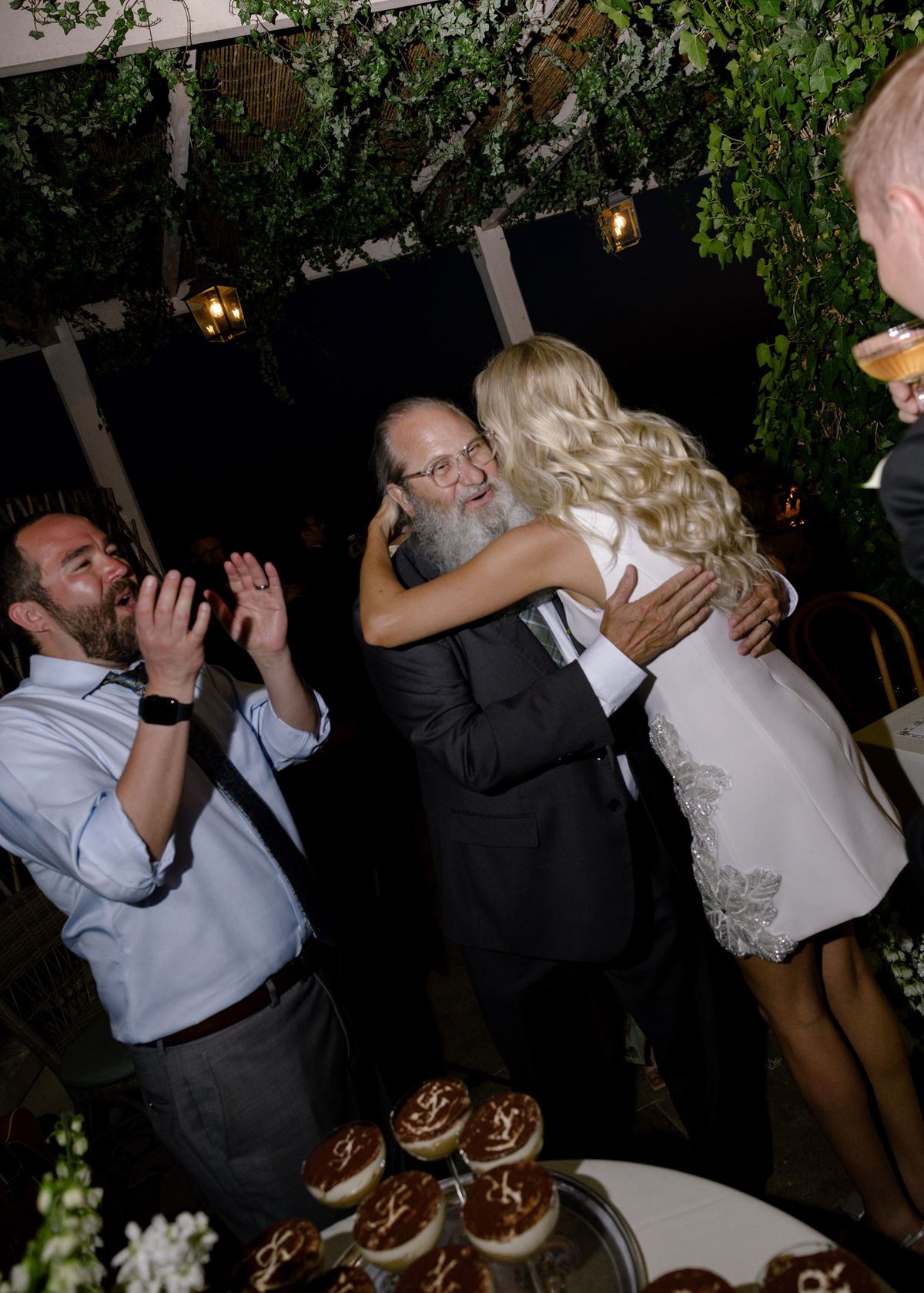 Bride hugging her father beside the tiramisù