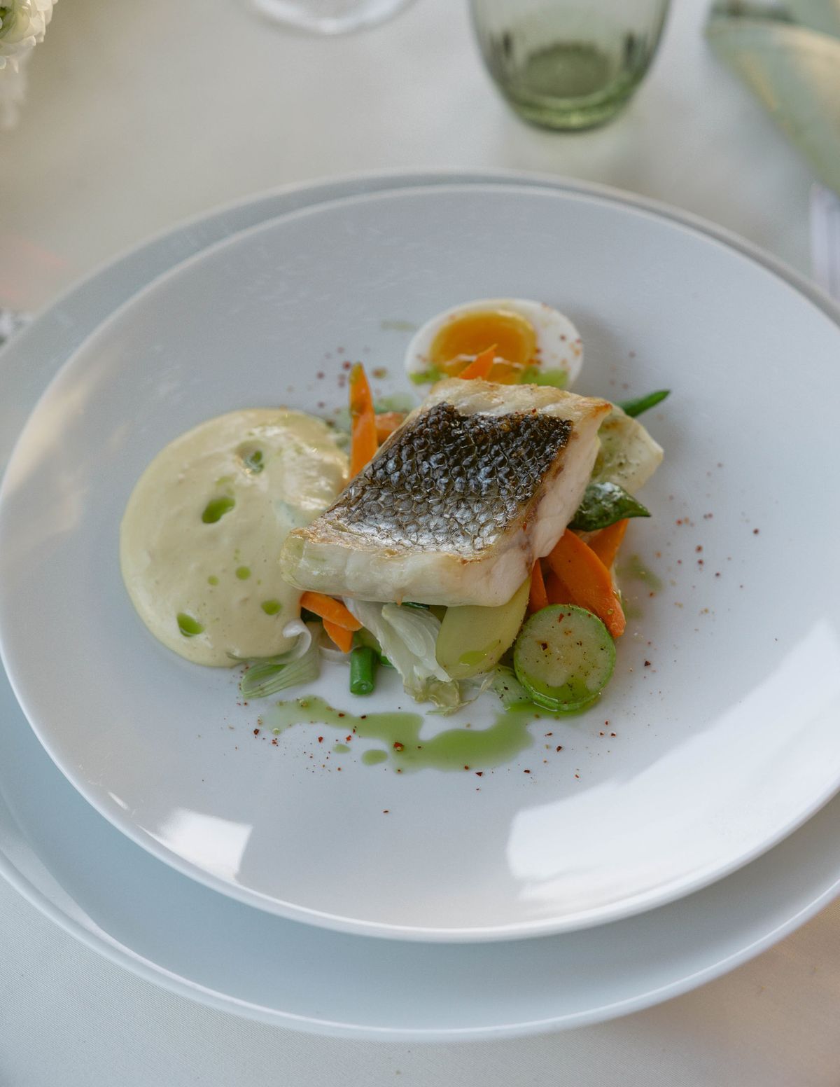 Plated fish course with vegetables