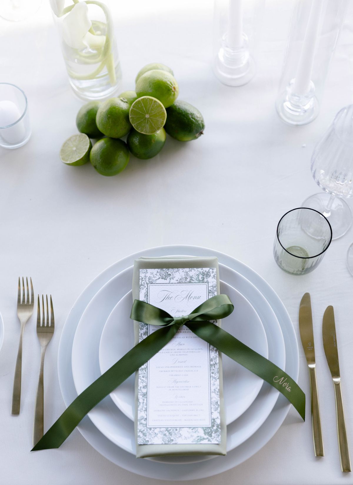 Place setting from above with a menu tied in green ribbon