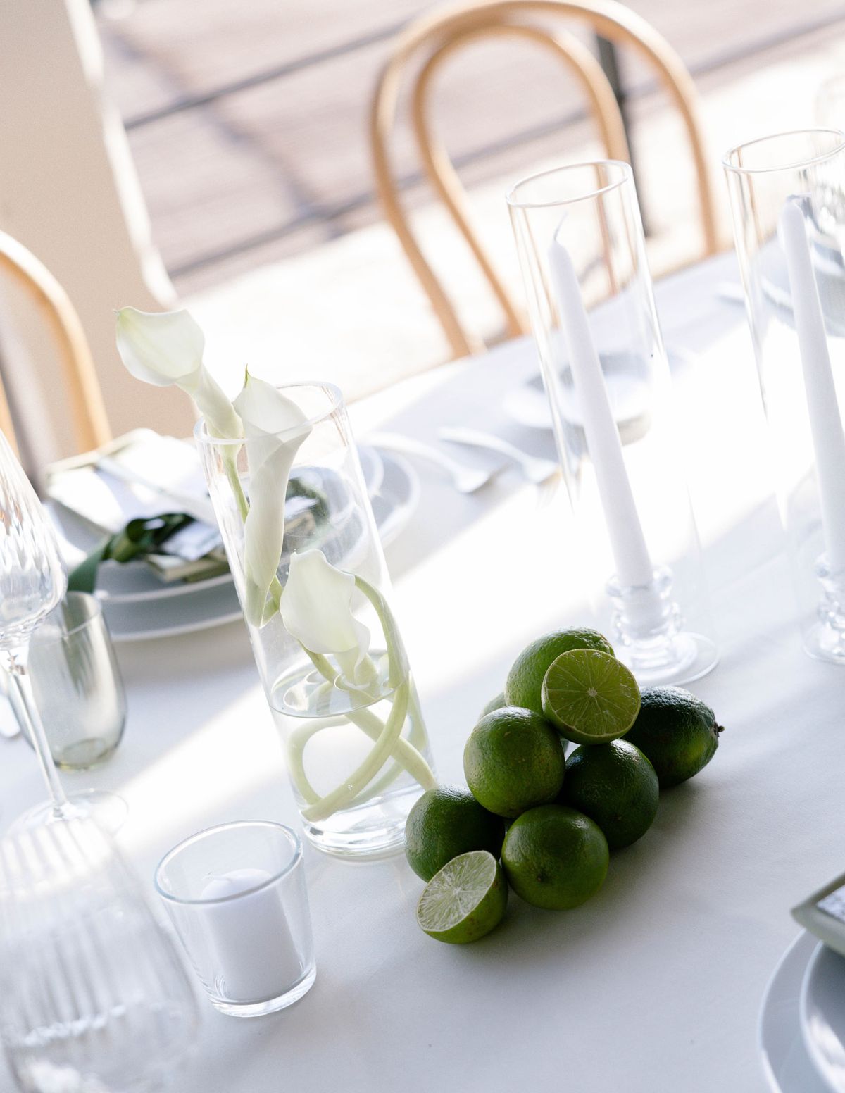 Limes and a calla lily centrepiece on a white tablecloth