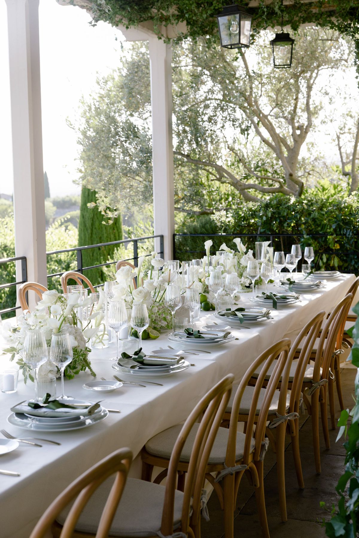 Long dinner table set on a covered terrace