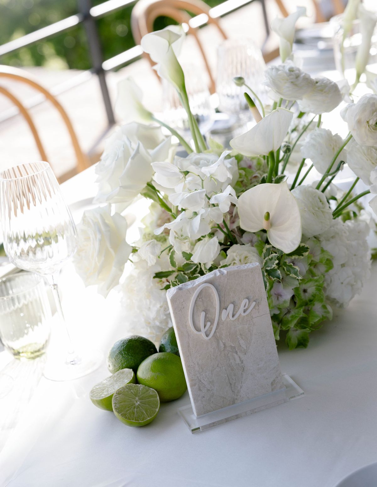Centrepiece of white flowers and limes with a table number