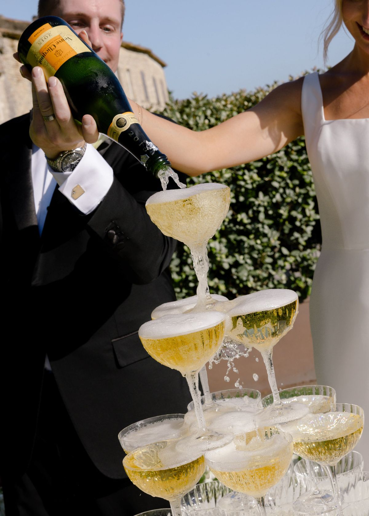 Kirstin and Ryan pouring champagne into a coupe tower, close up