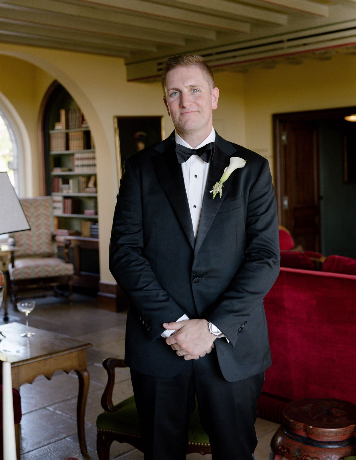 Groom in a tuxedo in a sitting room