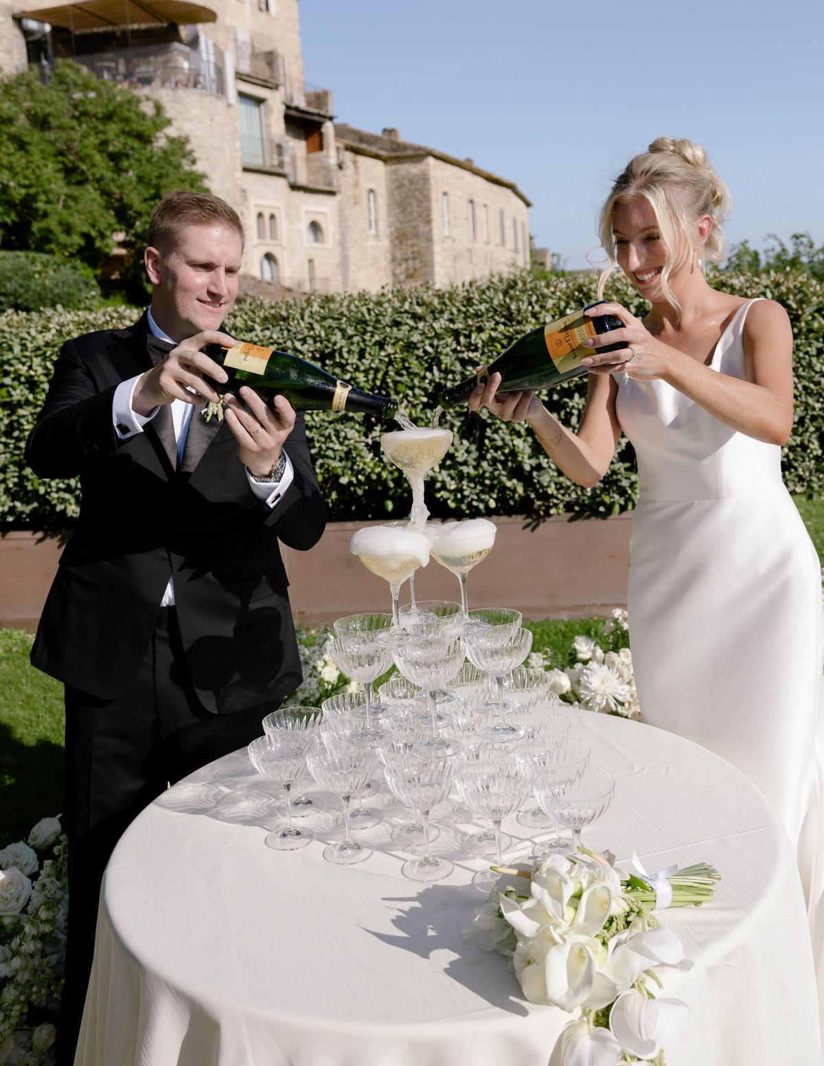 Kirstin and Ryan pouring champagne into a coupe tower