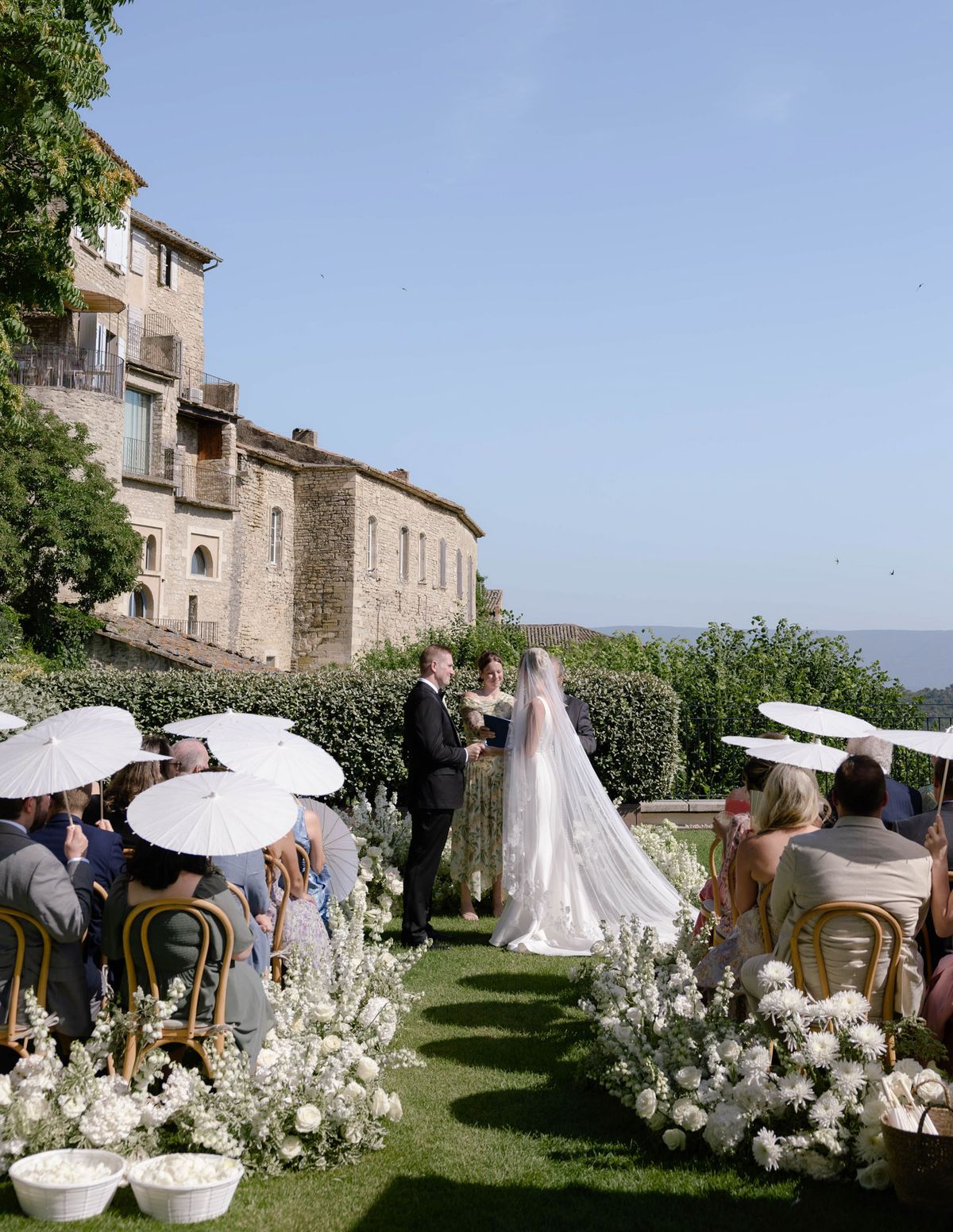 Kirstin and Ryan facing each other at the ceremony under a blue sky