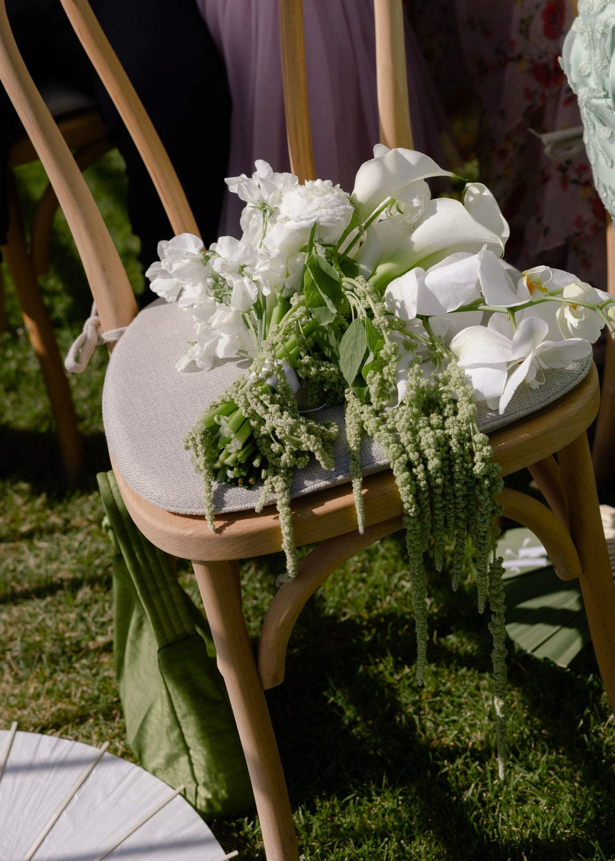 White calla lilies and greenery on an aisle chair