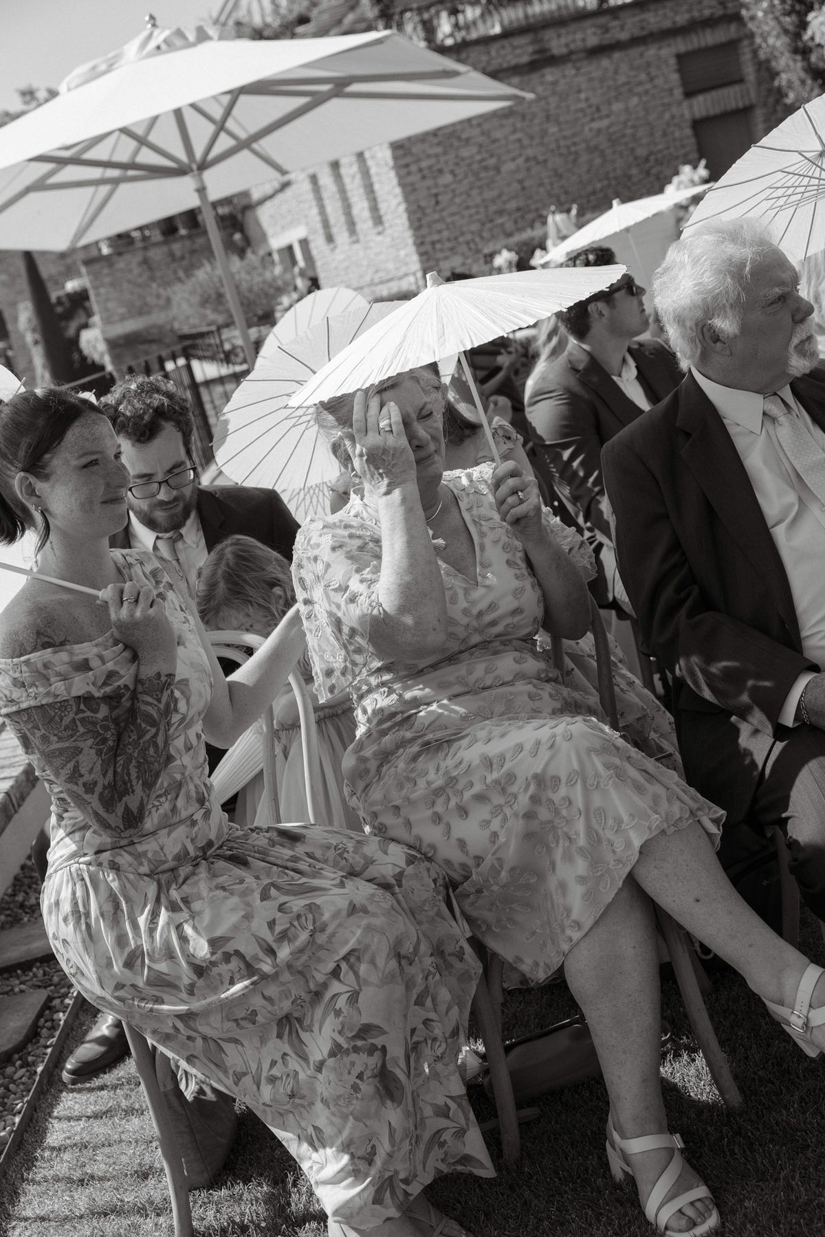 Black and white photo of guests under parasols