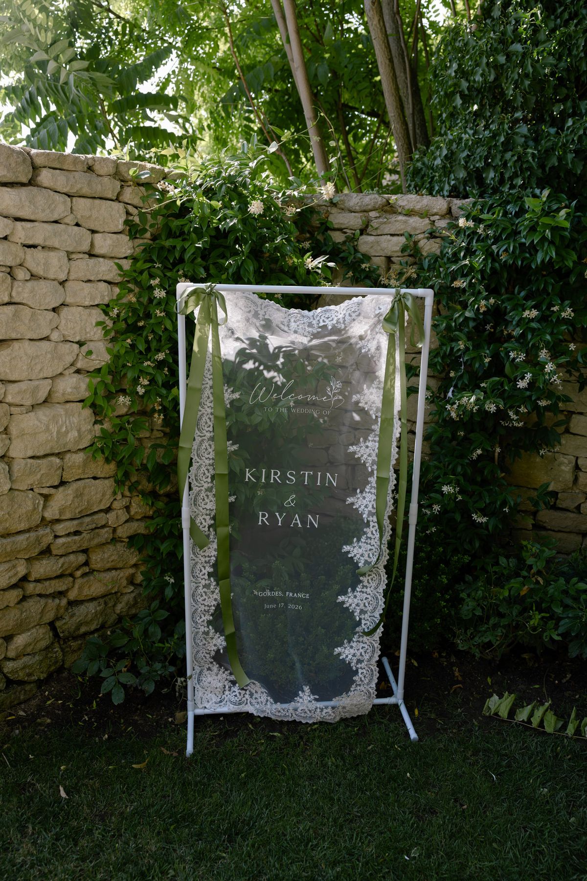 Lace welcome sign with Kirstin and Ryan's names in a stone courtyard
