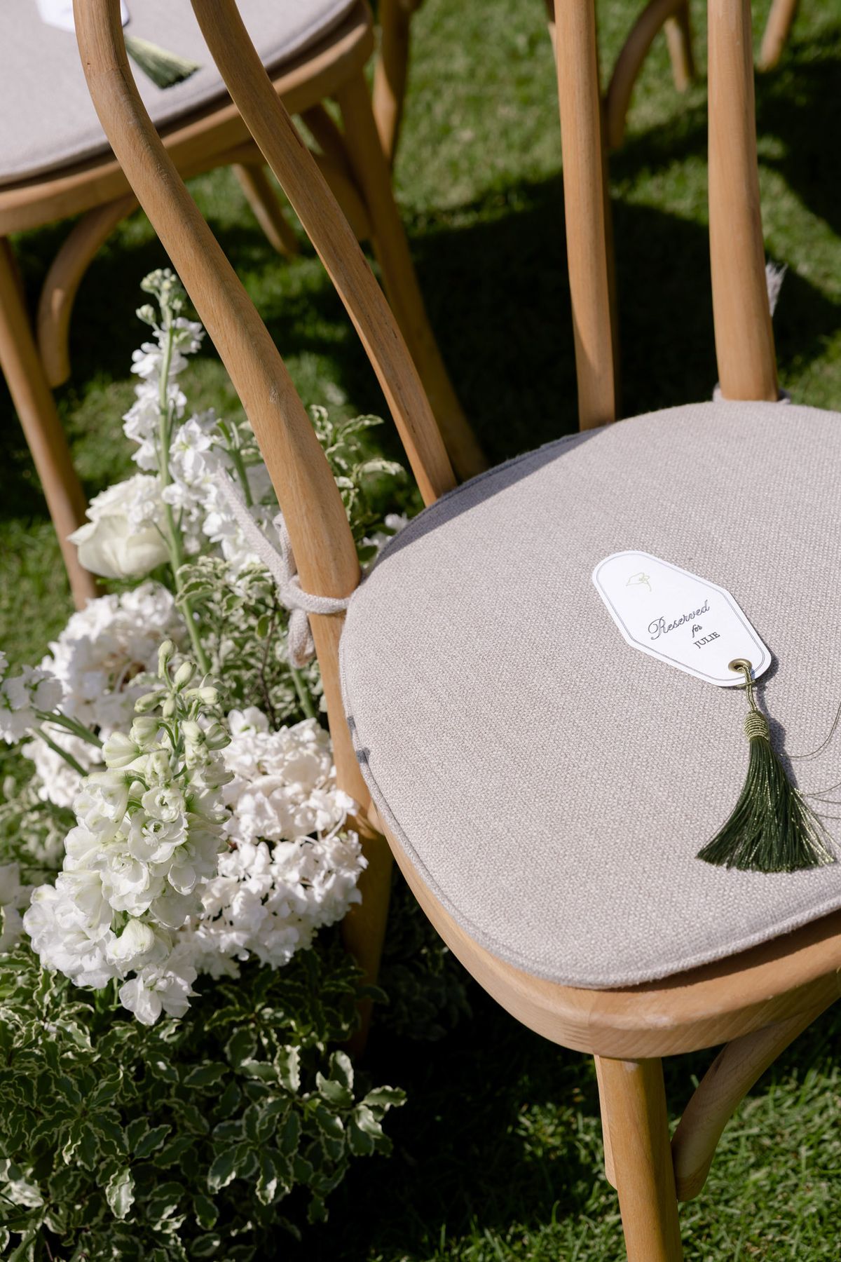 Ceremony chair with a tasselled name tag and white flowers