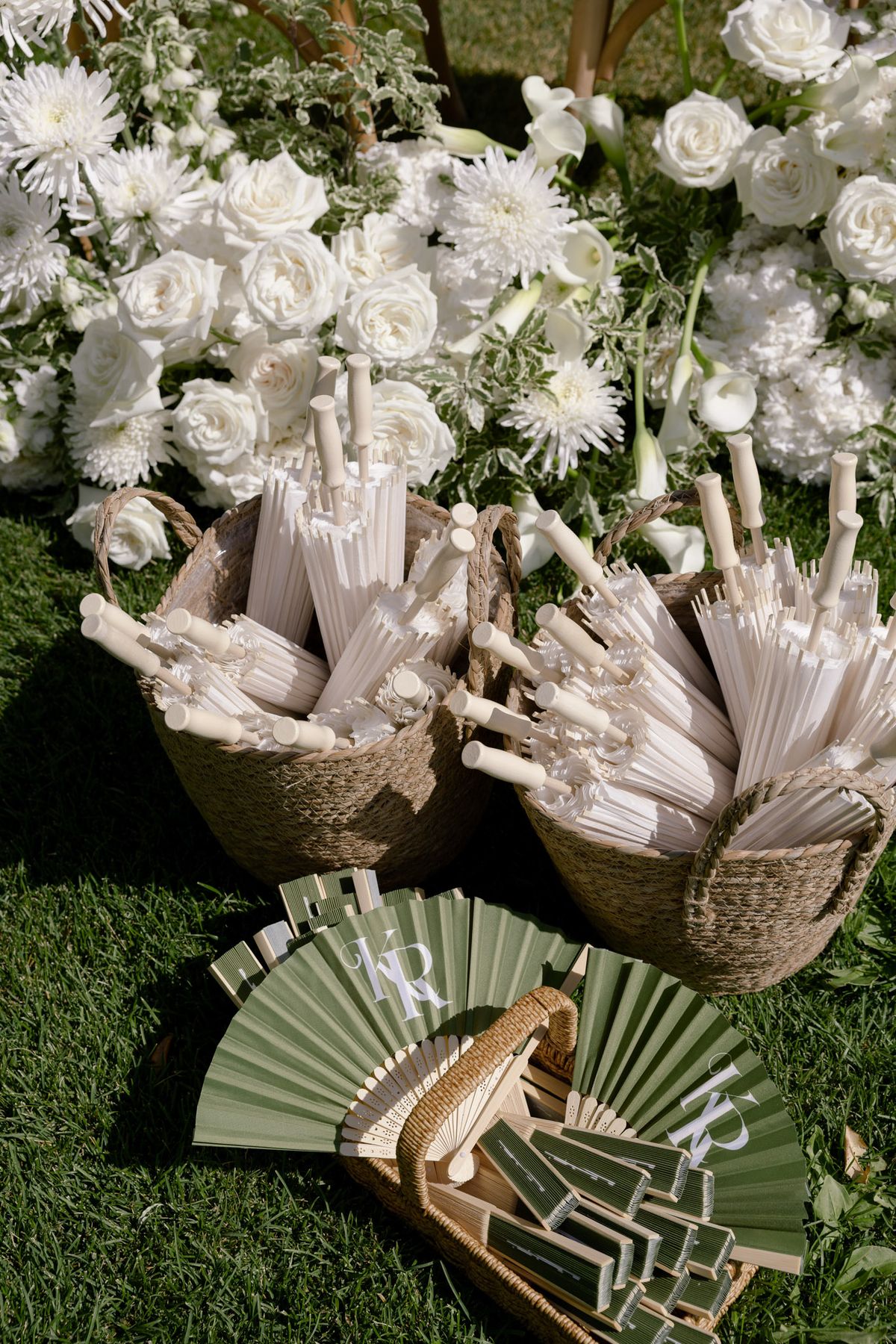 Baskets of paper parasols and green fans for ceremony guests