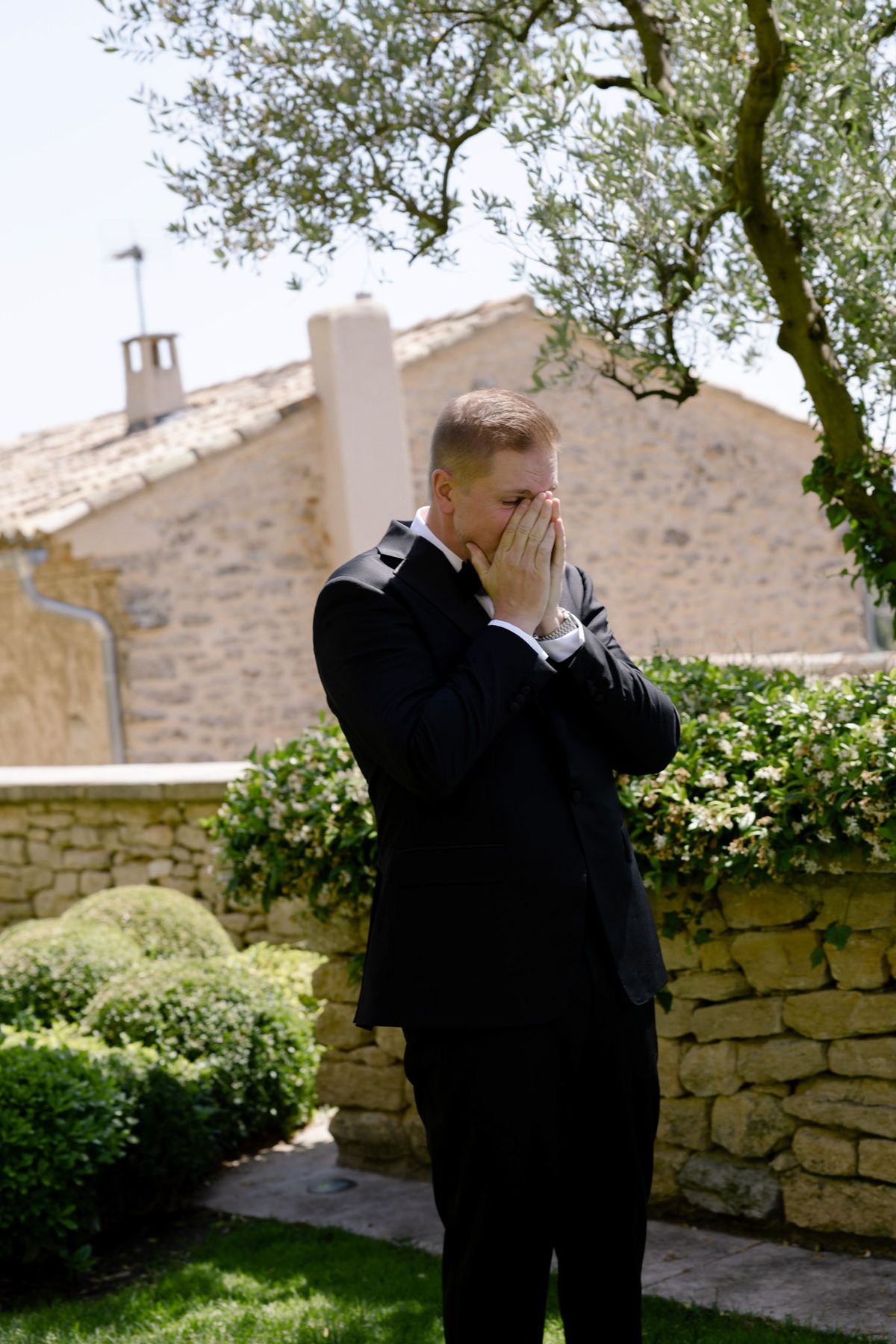Groom covering his face with emotion at the first look