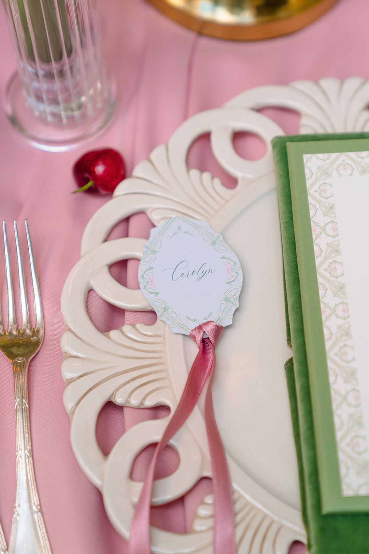 Place setting with scalloped charger, green menu and ribbon-tied name card