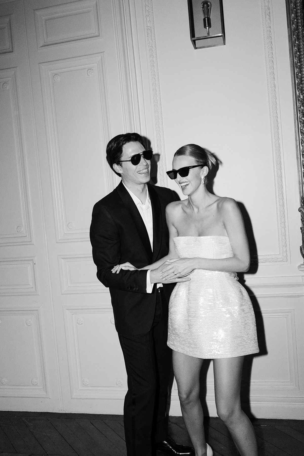 Black and white photo of the bride and groom in sunglasses at the evening party