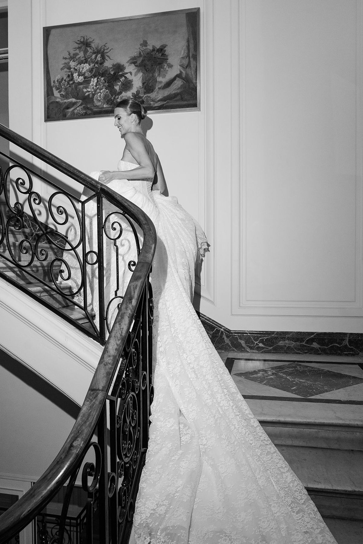 Black and white photo of the bride climbing the wrought-iron staircase at Hôtel Alfred Sommier