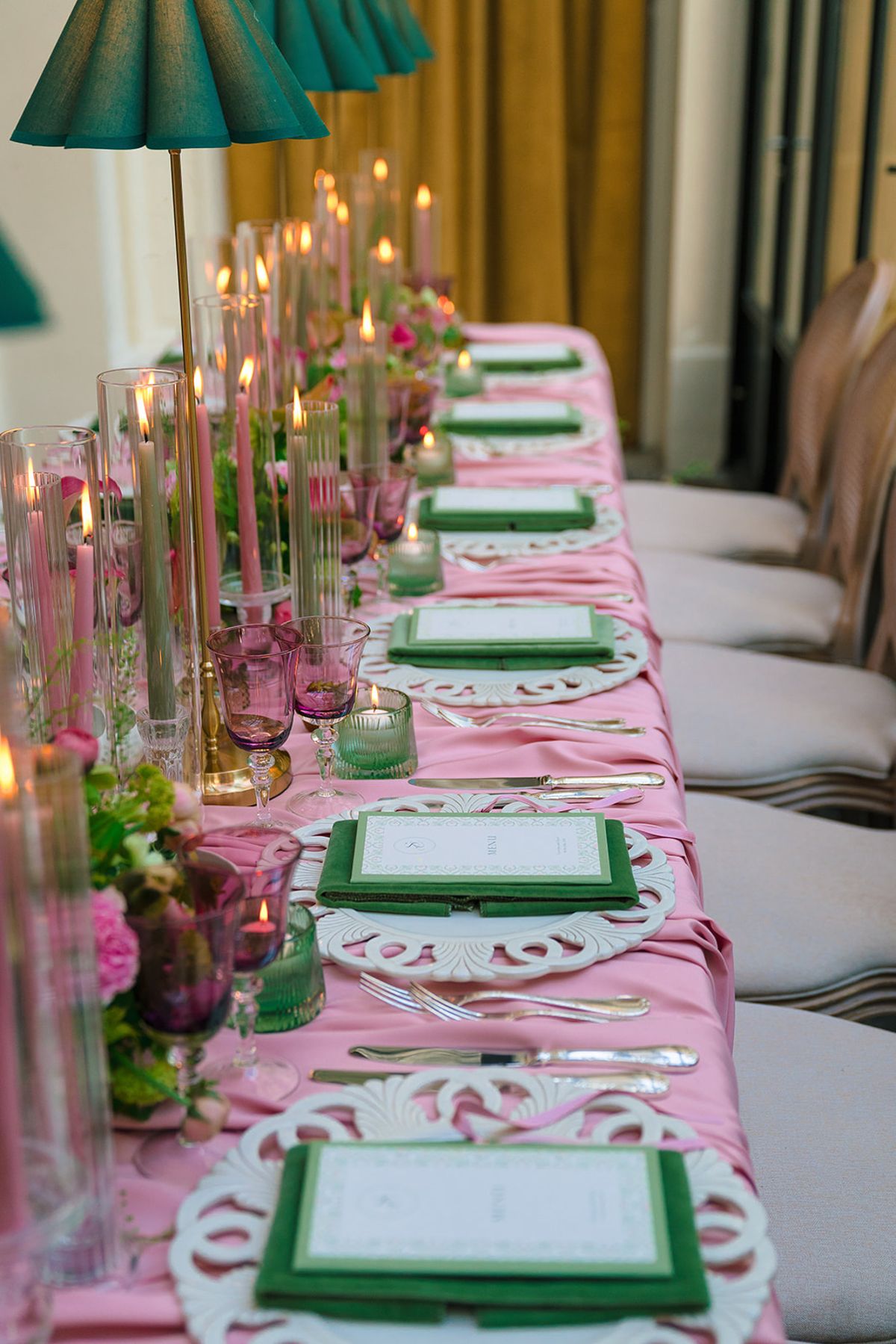 Long pink dinner table with green menus, taper candles and emerald lamps at Hôtel Alfred Sommier