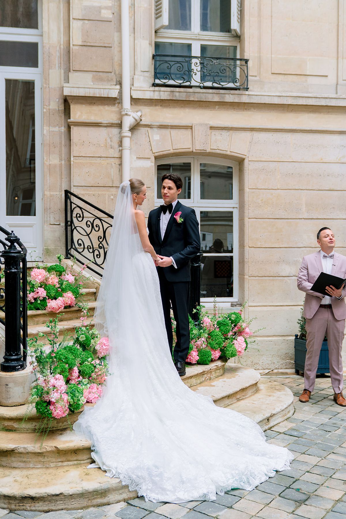 Bride and groom facing the celebrant on the hydrangea-lined courtyard steps at Hôtel Alfred Sommier