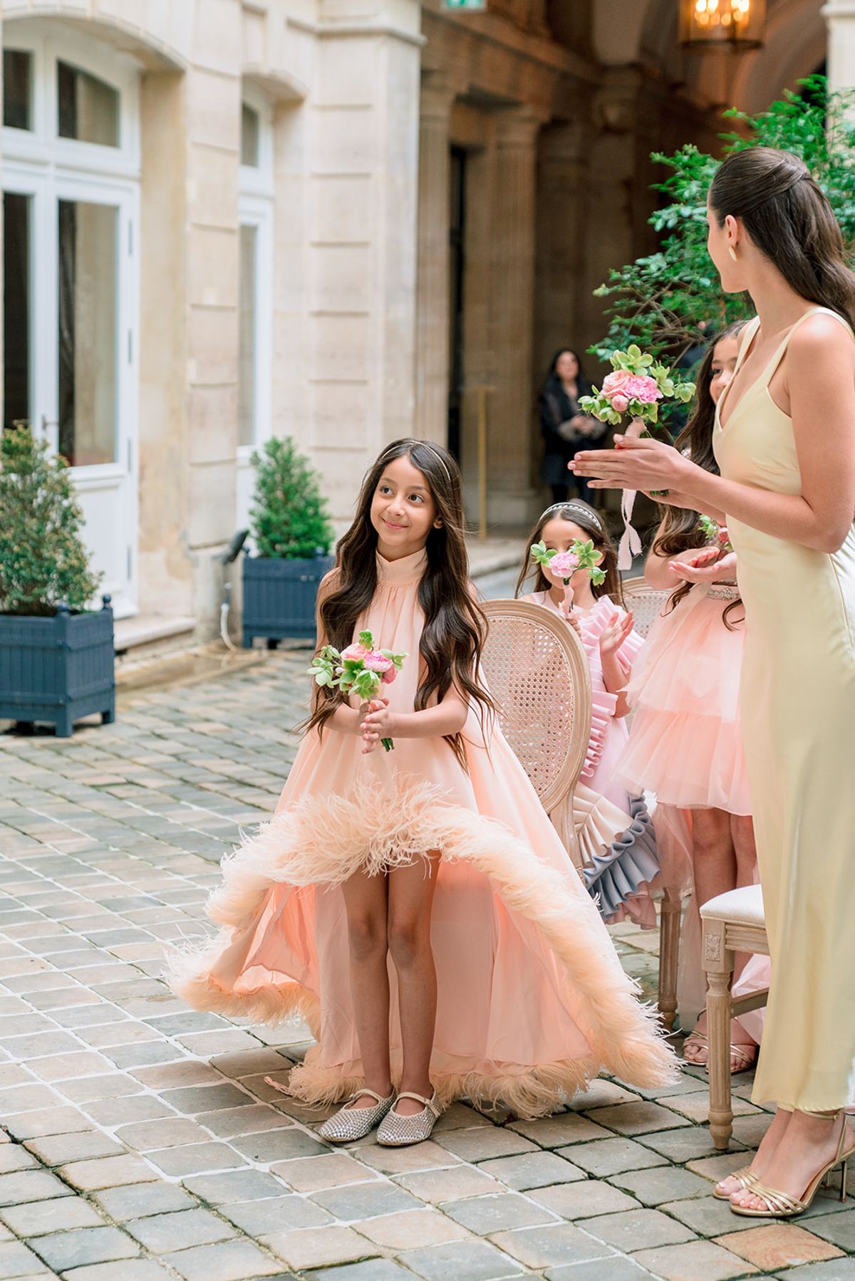 Flower girls in pink tulle dresses in the courtyard at Hôtel Alfred Sommier
