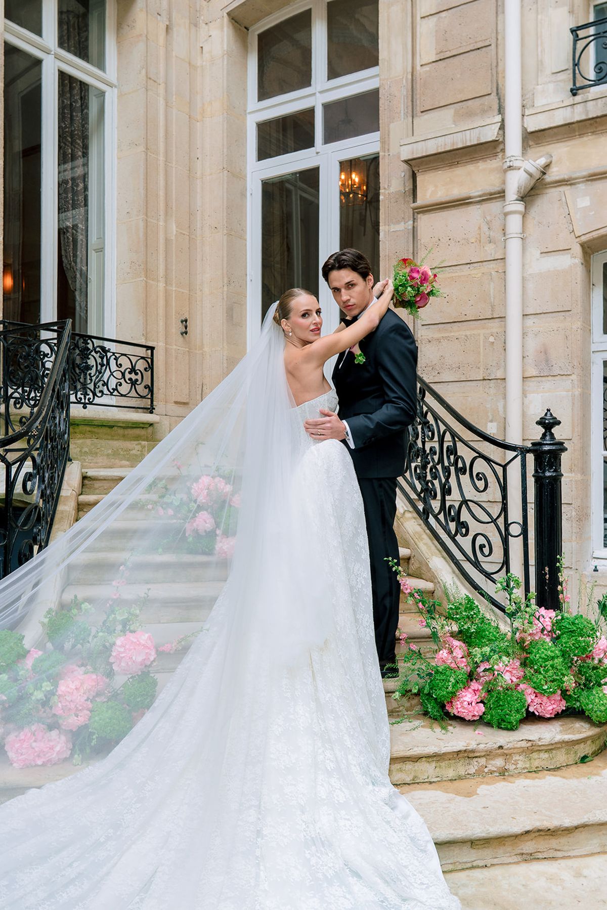 Bride and groom embracing on the courtyard steps with her veil in the breeze, Hôtel Alfred Sommier