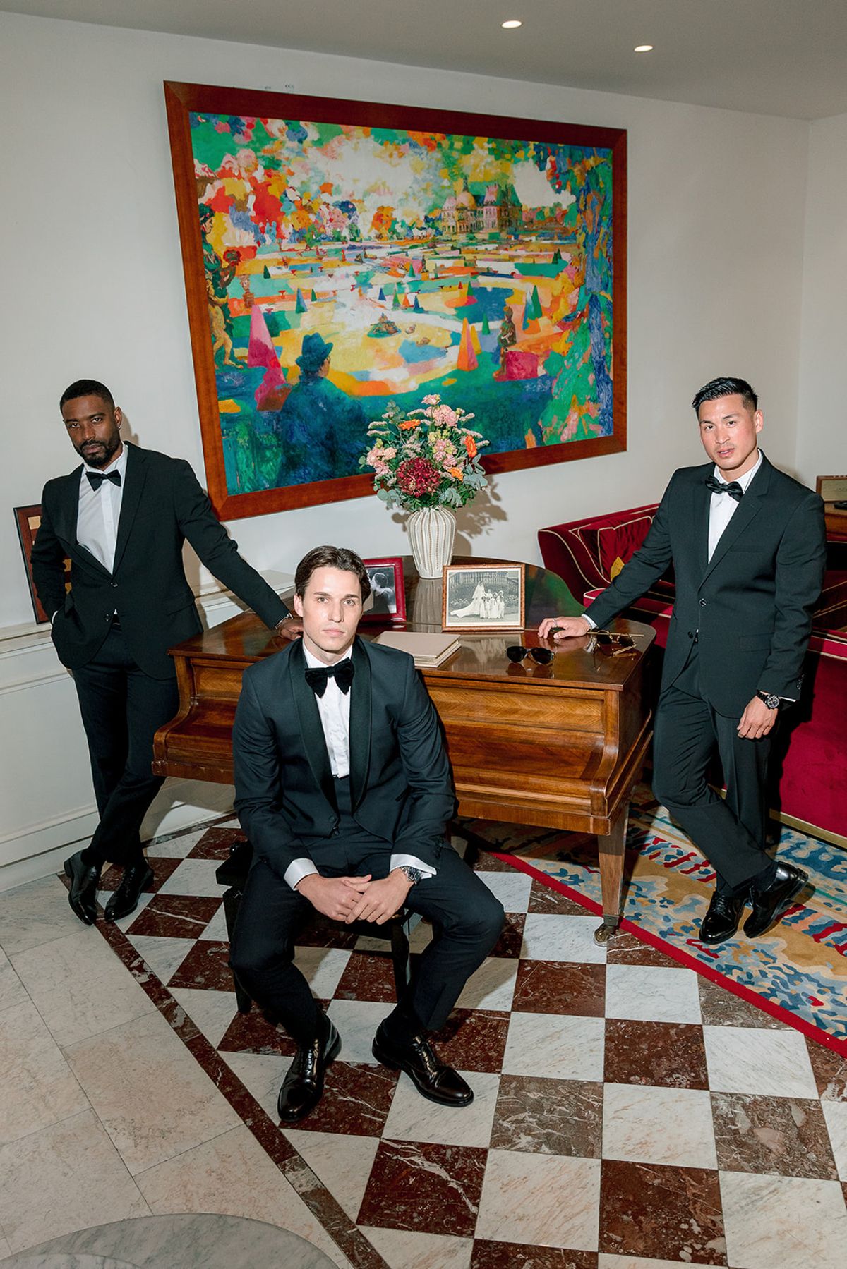 Groom and two groomsmen in black tie in a salon with a colourful painting, Hôtel Alfred Sommier