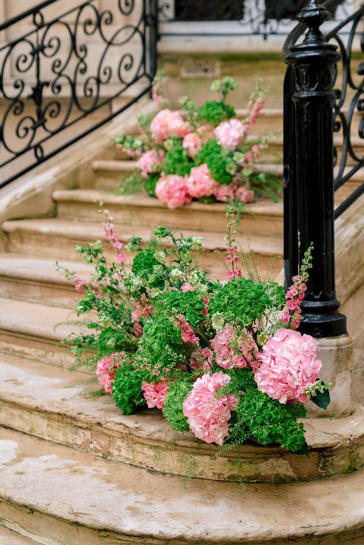 Pink hydrangeas and green florals on the courtyard stone steps at Hôtel Alfred Sommier