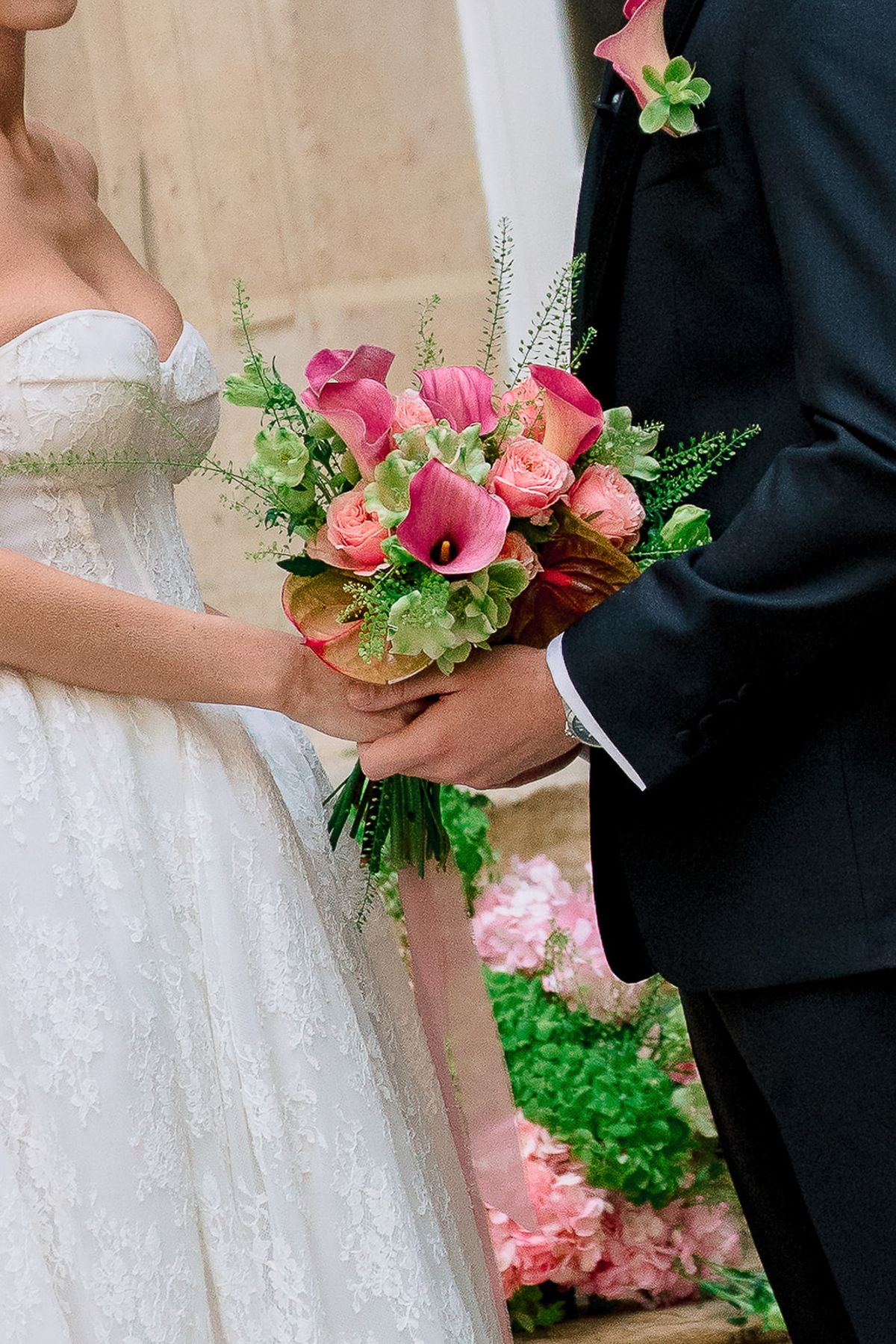 Bride holding a bouquet of pink calla lilies beside the groom before the vows