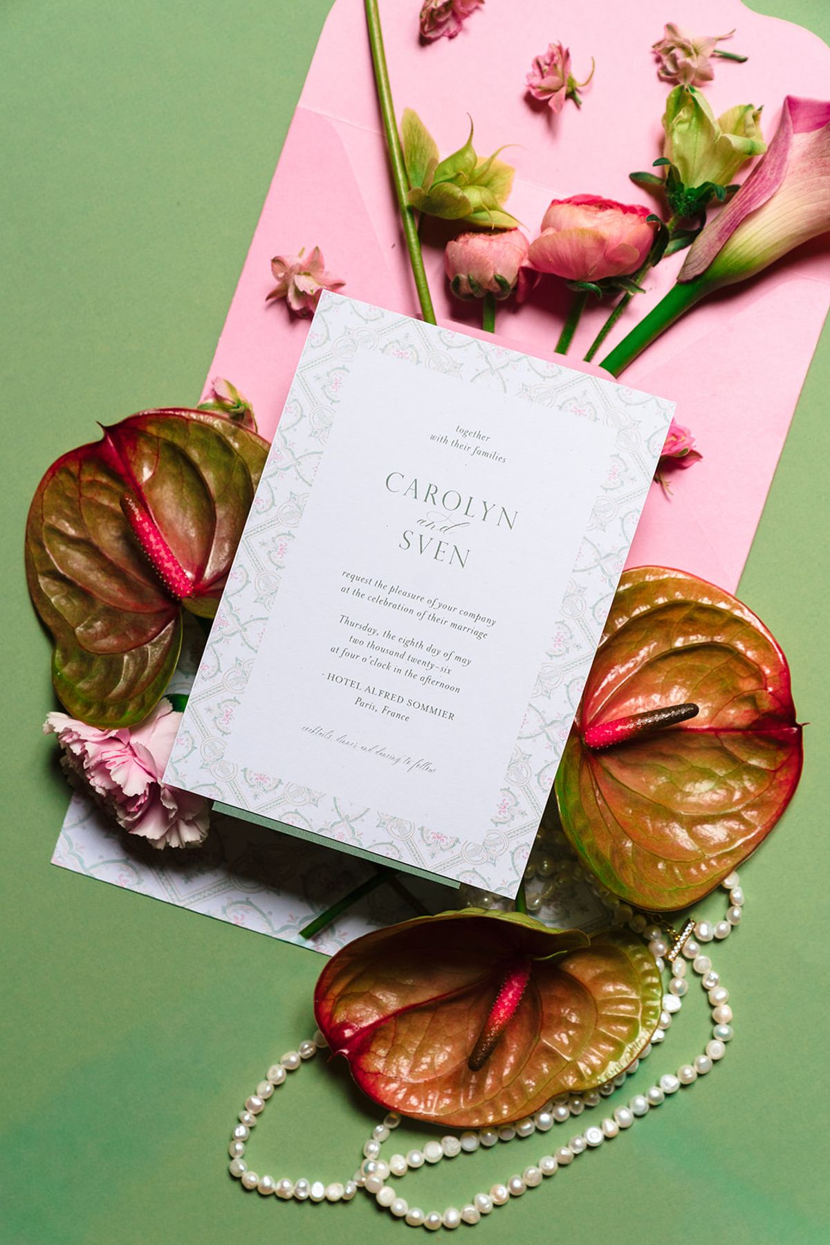 Wedding invitation with anthuriums, pink roses and pearls on a green background