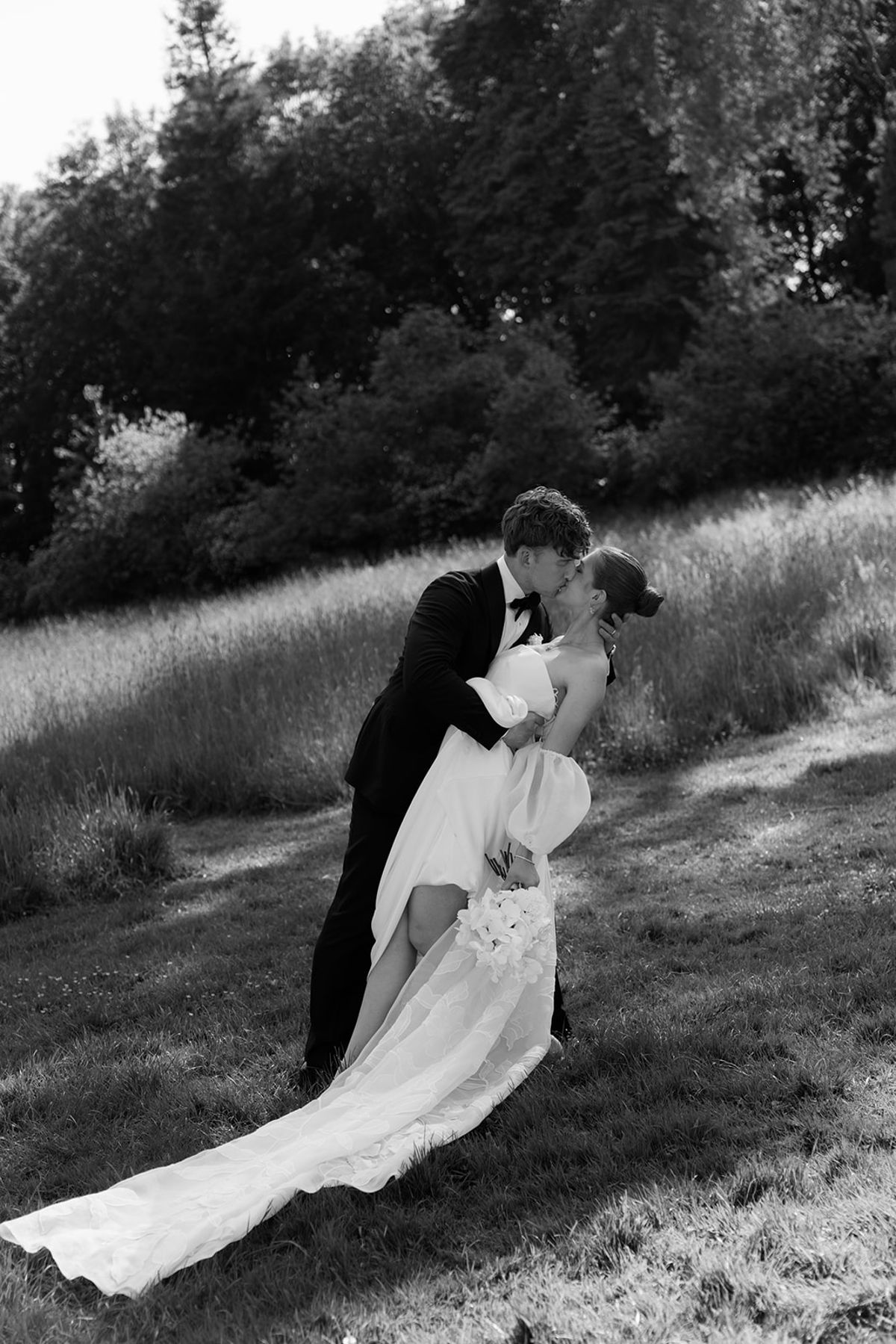 Bride and groom embracing in a field, black and white