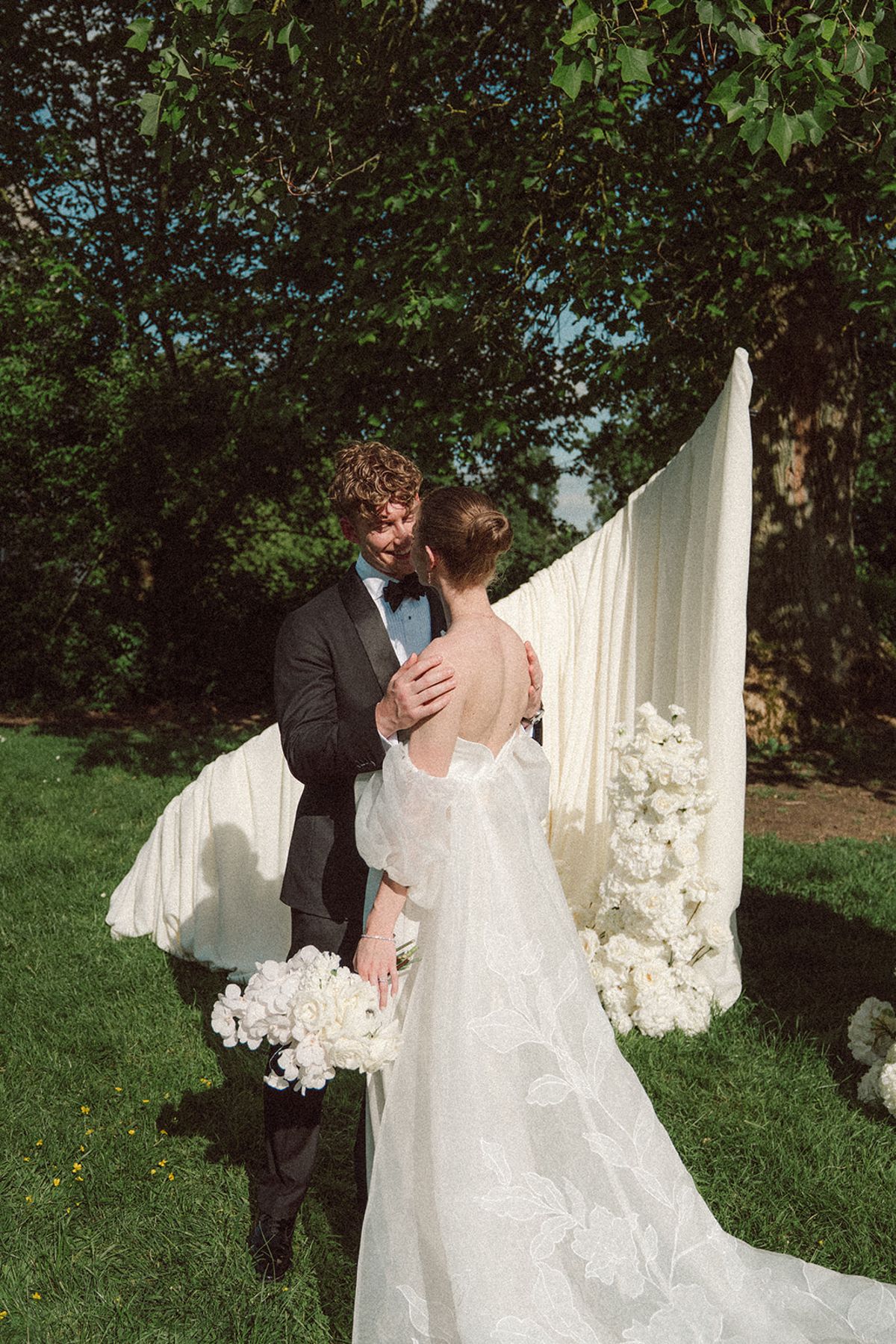 Bride and groom embracing at the ceremony arch