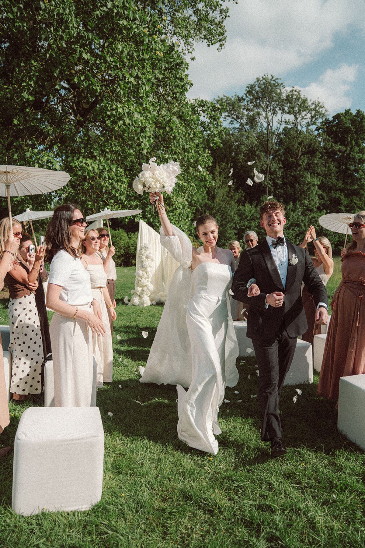 Guests throwing petals as the couple celebrates after the ceremony