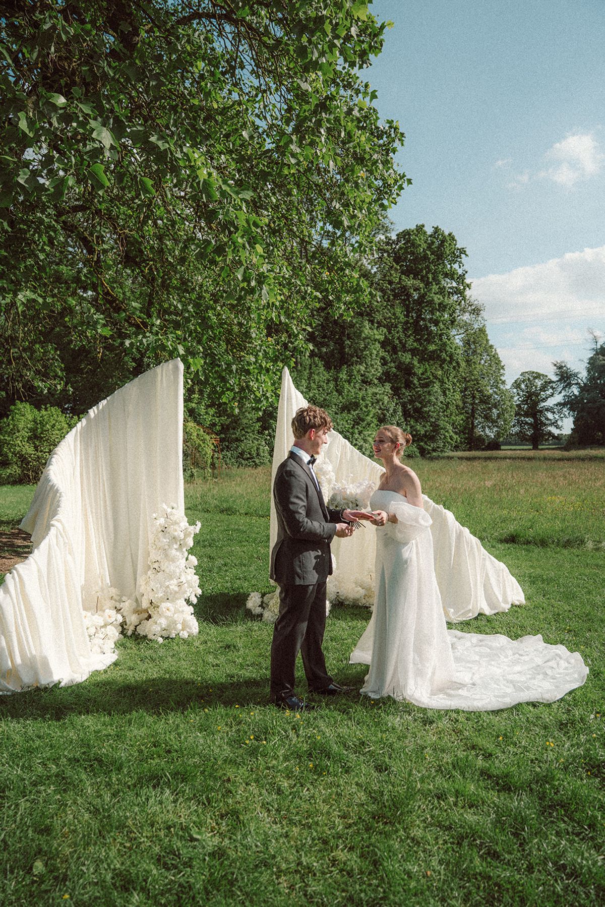 Bride and groom exchanging vows at the ceremony arch