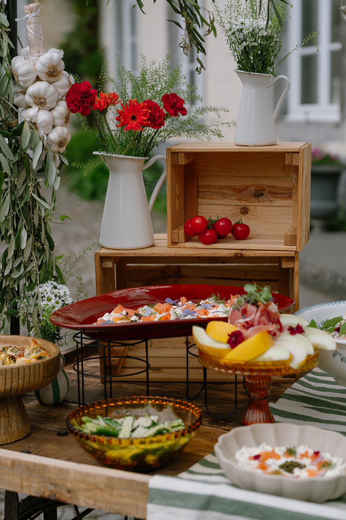 Styled grazing spread with cherry tomatoes and citrus in a wooden crate