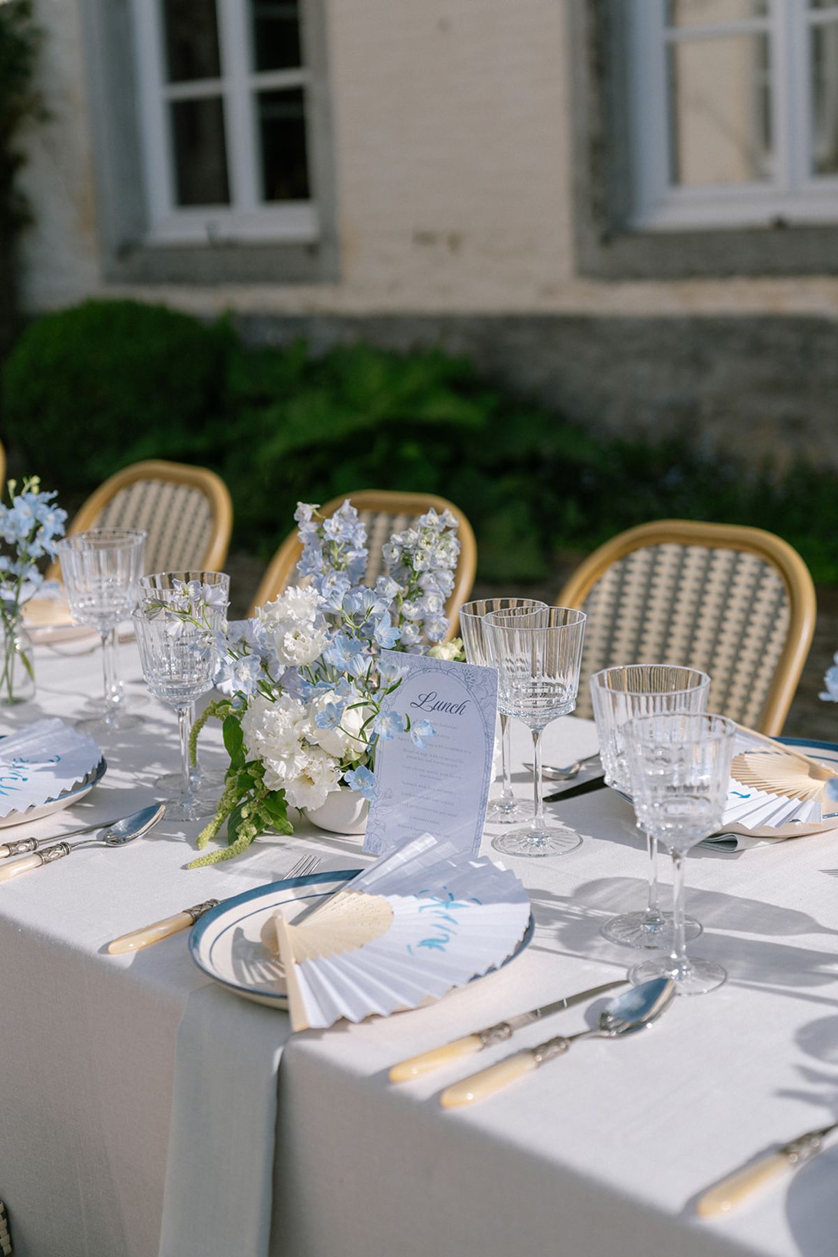 Table setting in blue and white with a delphinium centrepiece