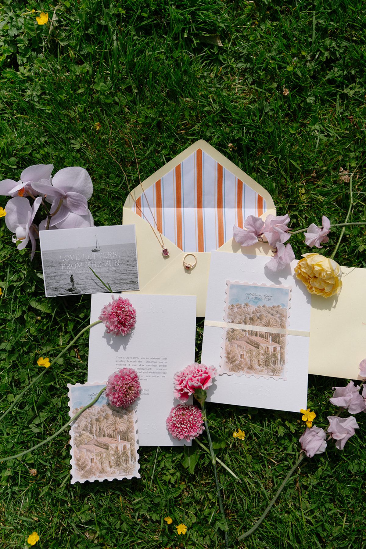 Wedding stationery flat lay with pink and purple florals