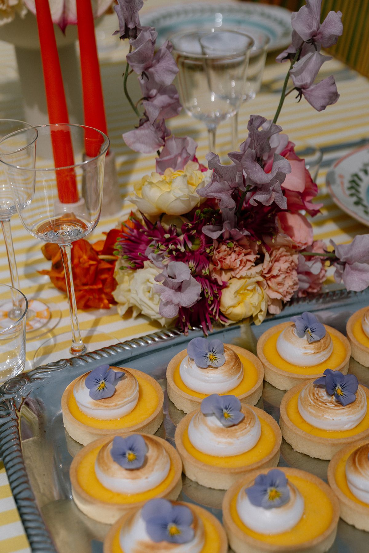 Dessert table with mini cupcakes, candles and pastel florals
