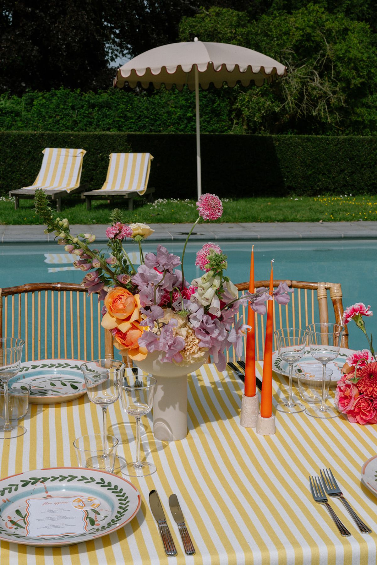 Poolside floral centrepiece with lounge chairs behind