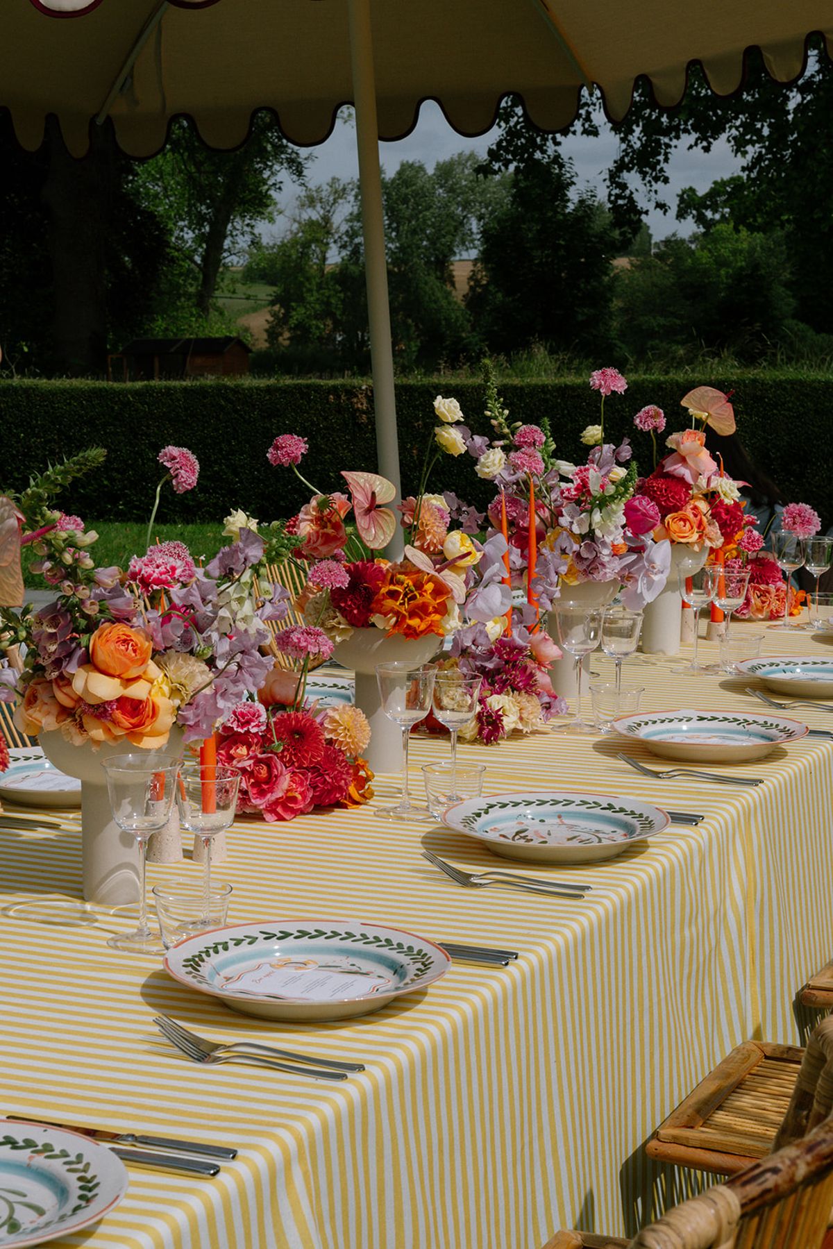 Pink and orange floral centrepiece with taper candles