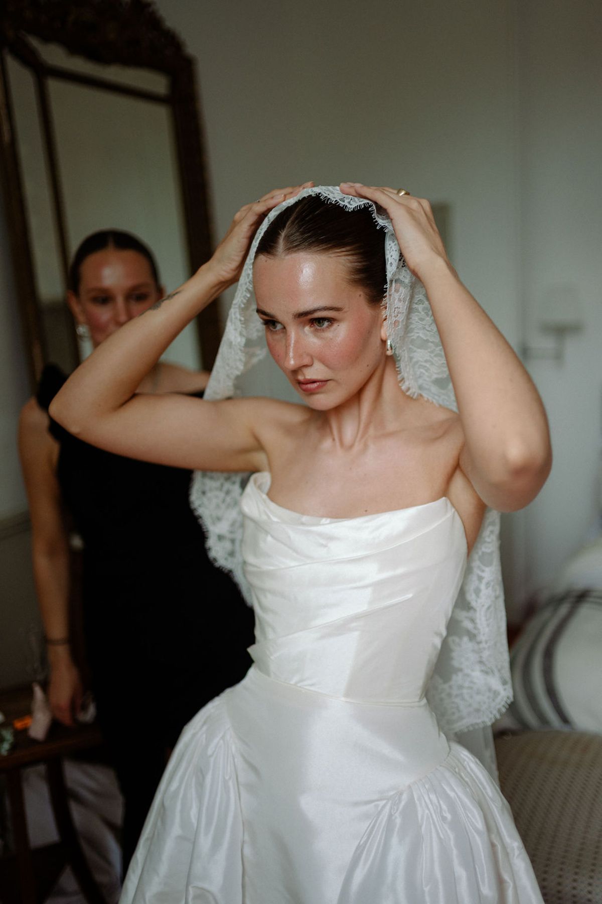 Clara adjusts her veil before the ceremony