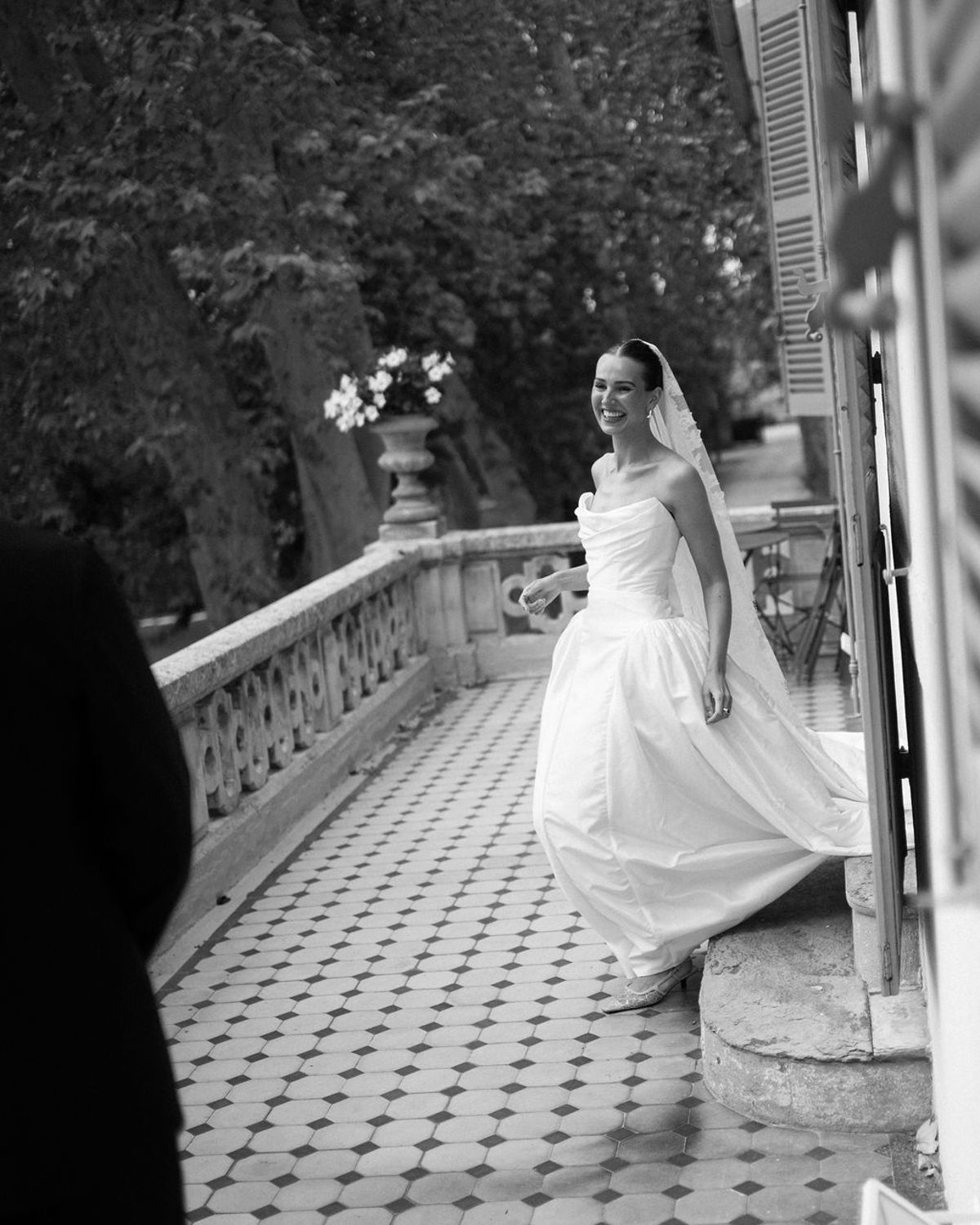Clara walks along the balustraded terrace of Bastide de Toursainte in her wedding dress