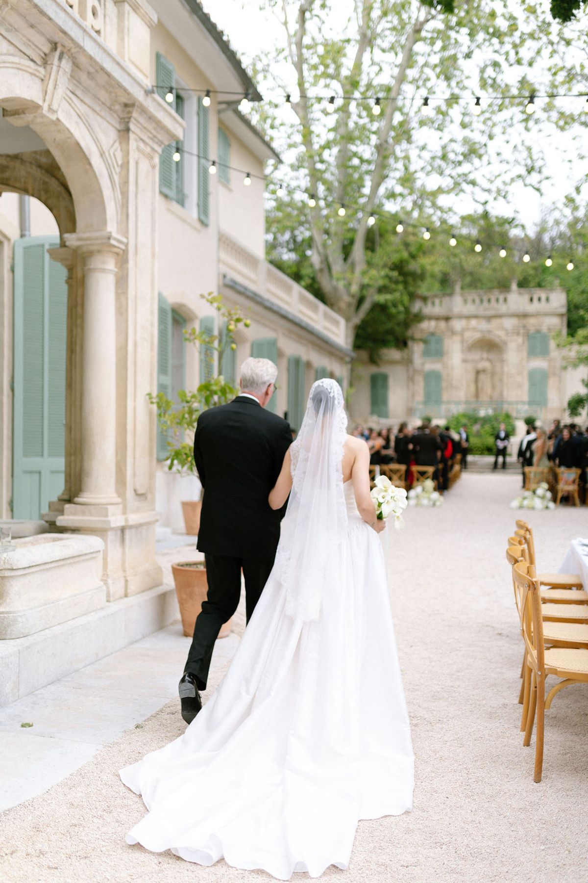 Guests are seated along the ceremony aisle at Bastide de Toursainte