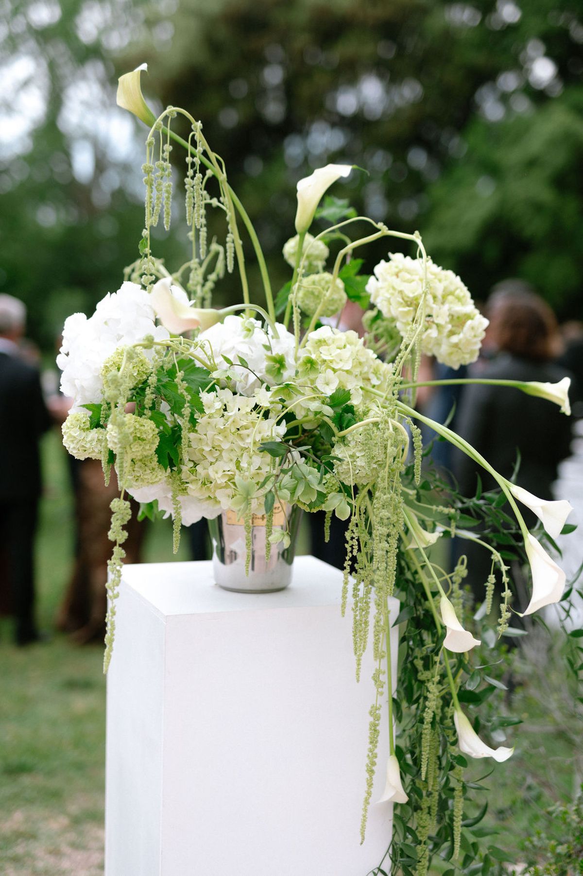 A white floral arrangement of roses and greenery