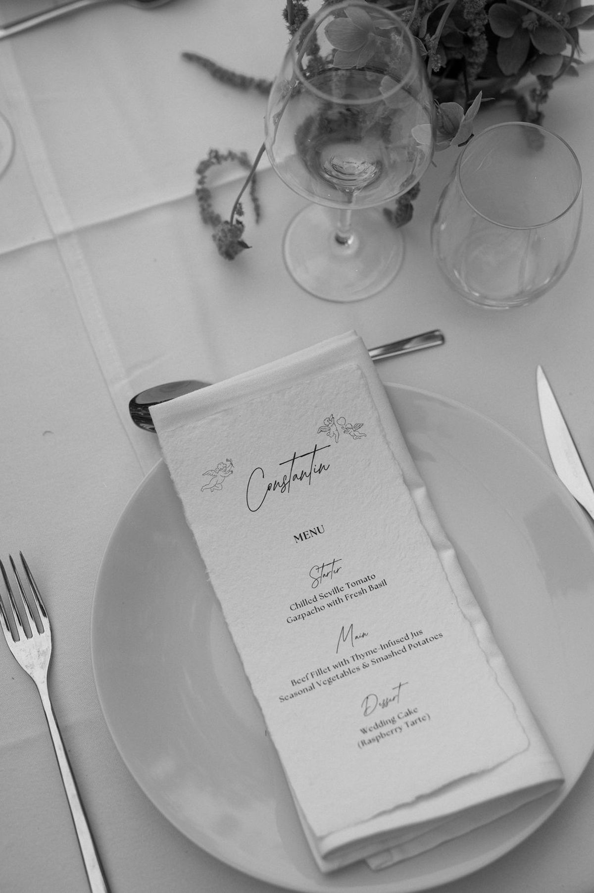 A menu card set on a place setting, captured in black and white
