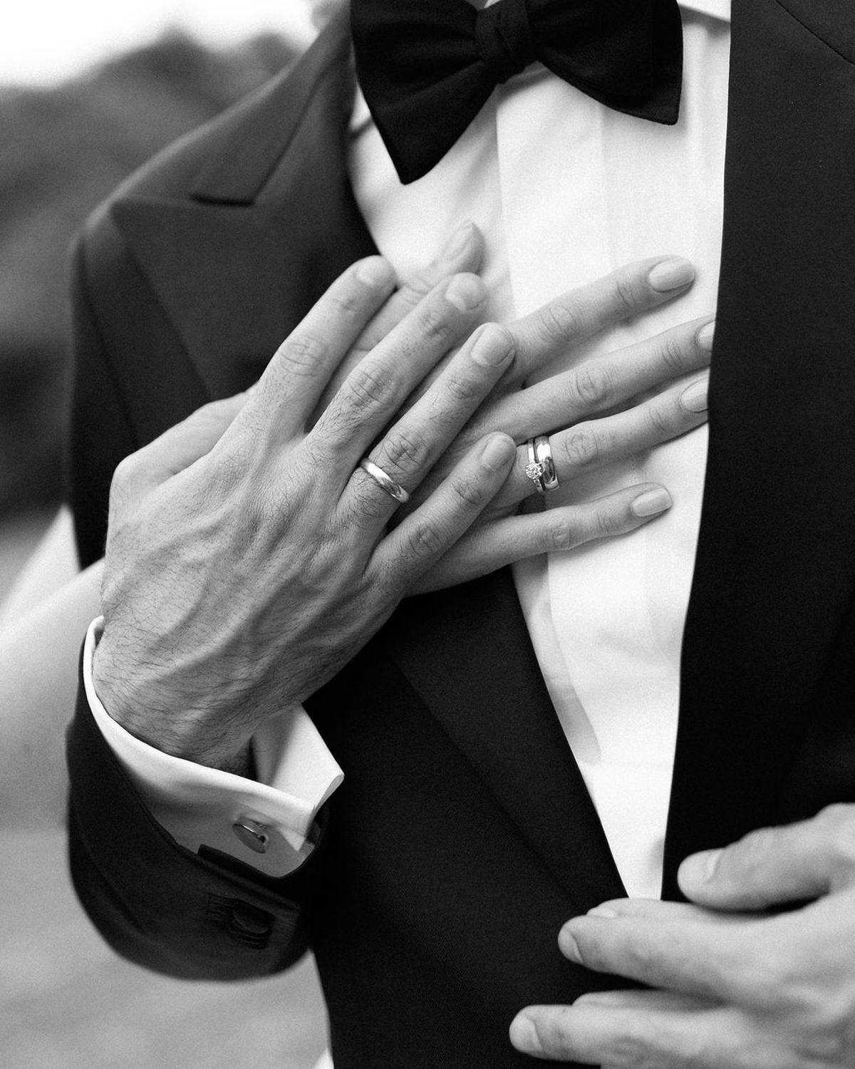 A close view of Clara and Constantin's hands, their wedding rings visible, in black and white